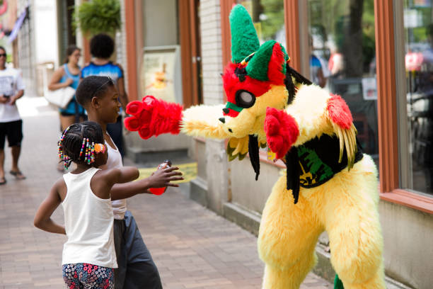 Pittsburgh, PA, USA - June 29, 2017: A furry in town for Anthrocon 2017 reaches out for a hug from two young children on the streets of downtown Pittsburgh, PA. The Anthrocon convention is held in Pittsburgh, PA every year for people fascinated with dressing like animals and other human-like animal characters.