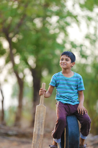 istock Rural Indian Child Playing Cricket 813291500