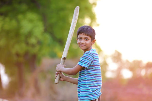 istock Rural Indian Child Playing Cricket 813296040
