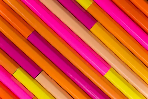 Collection of rose orange pencils in a diagonal line pattern as background picture"n