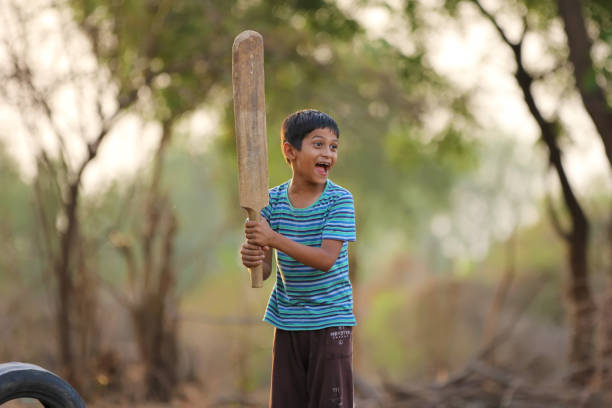 istock Rural Indian Child Playing Cricket 813303626