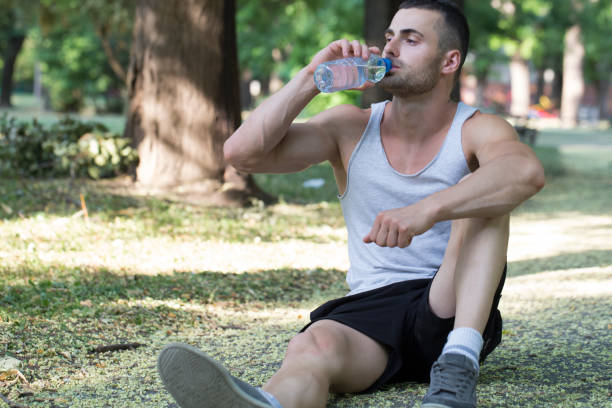 istock He drinks water from the bottle and rests in the park after training 813304012