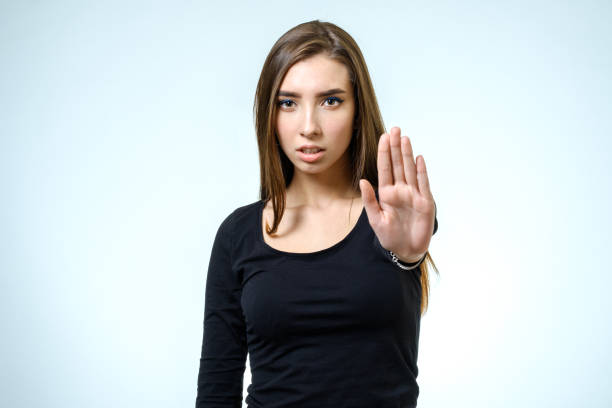 Young woman making rejection pose on white background