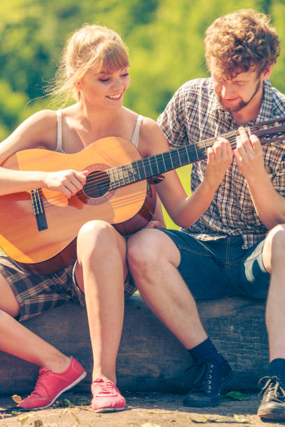 istock Young couple camping playing guitar outdoor 813312128