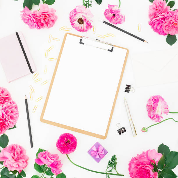 istock Workspace with clipboard, notebook, purple flowers and accessories on white background. Flat lay, top view. 813312334