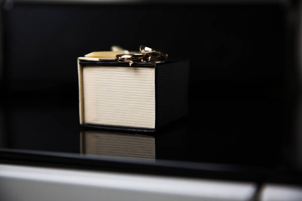 istock Bride and groom rings in wedding box on black background 813320056