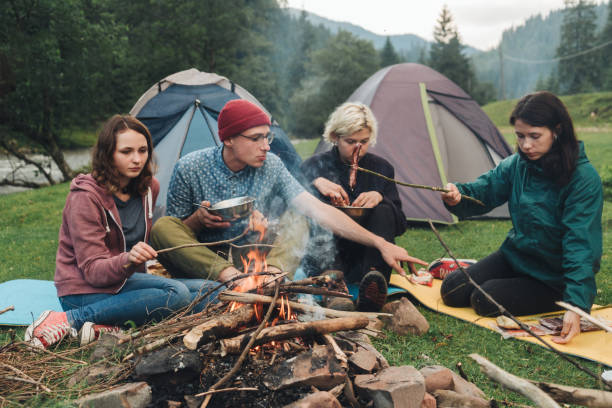 istock Friends sitting near the campfire in camping 813338480