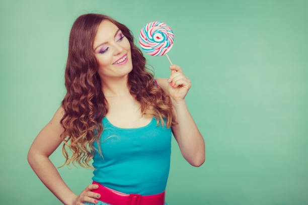 istock Smiling girl with lollipop candy on teal 813338894