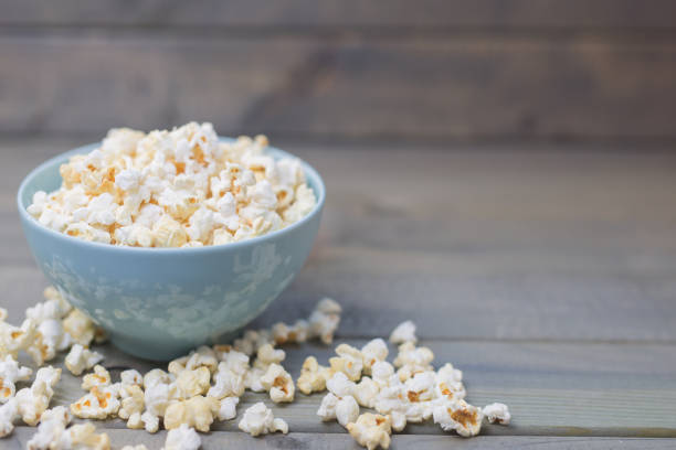 パステル ブルーのボウルでポップコーン - popcorn snack bowl corn ストックフォトと画像