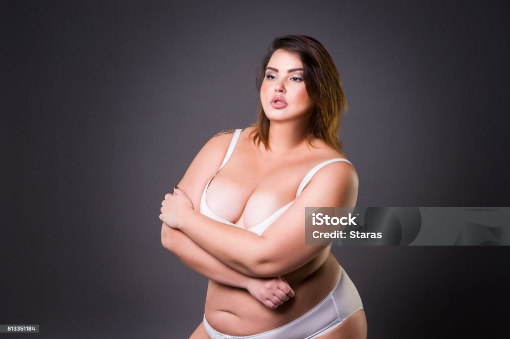 Modello di moda plus size in biancheria intima, giovane donna grassa su sfondo grigio, corpo femminile in sovrappeso - Foto stock royalty-free di Nudo
