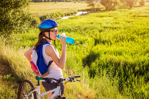 istock Young bicyclist drinking water by the river 813365694