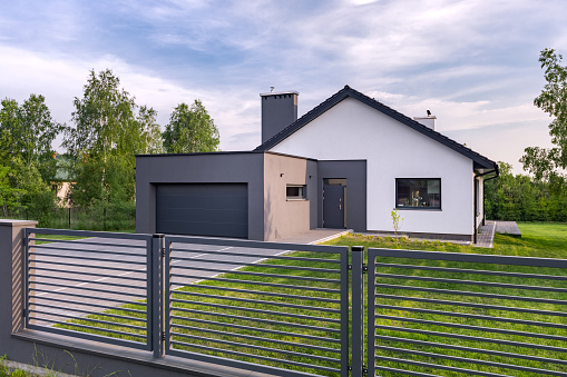 Stylish villa with fence, garage and lawn, exterior view