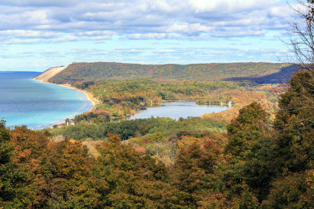 A view of South Bar Lake and Lake Michigan, as seen from Empire Bluff Trail. Sleeping Bear Plateau, part of Sleeping Bear Dunes is a dominant part of the scene. South Manitou Island can be seen in the distance.