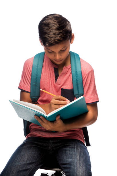istock Latin schoolboy sitting and writing 813376182