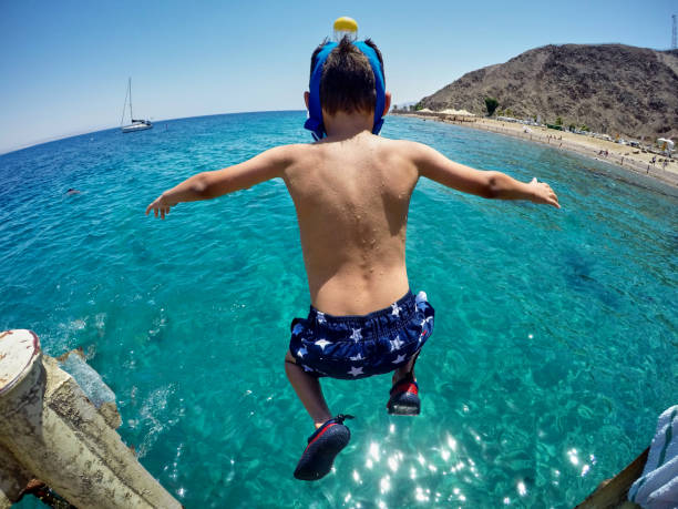 Happy boy swims and dives underwater. Active healthy lifestyle, water sports and activities with parents on summer family vacation with child.