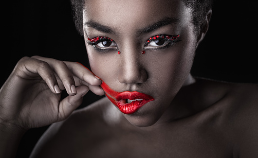 Close-up of a beautiful black woman with fashion make-up, red lips. Glamorous portrait