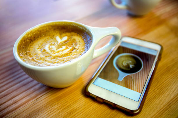 istock Latte on a Table with a Smart Phone Photo of it 813402328