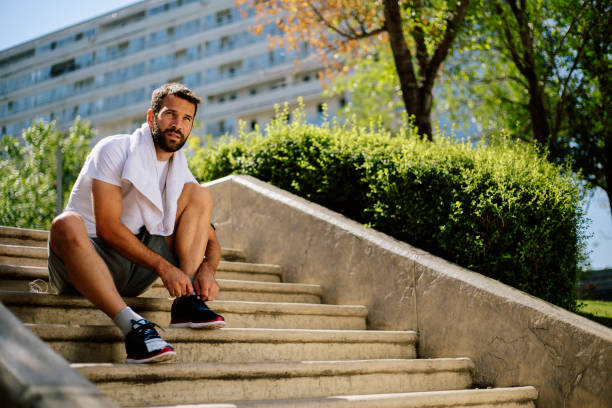 istock Young man sitting at stairs and preparing for trainng 813413464