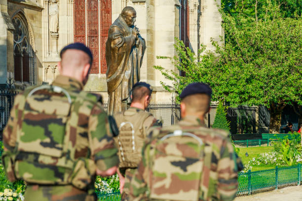 Pope John Paul II with soldiers PARIS, FRANCE - JULY 1, 2017: Pope John Paul II statue guarding soldiers of National Armed Forces in Notre Dame of Paris, keeping security after recent terrorist attacks in Paris. pope john paul ii stock pictures, royalty-free photos & images