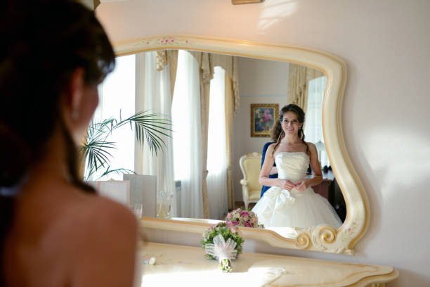 istock Bridesmaid is lacing white wedding dress for beautiful bride 813416426