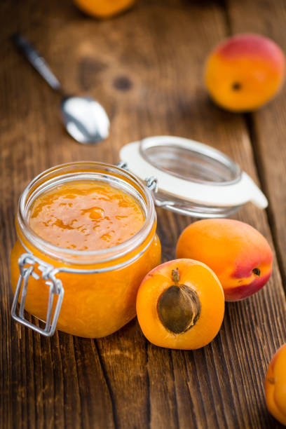 istock Portion of Apricot Jam on wooden background (selective focus) 813416492