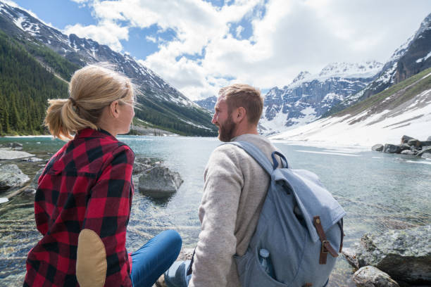 istock Hiking couple relaxing by mountain lake 813428068