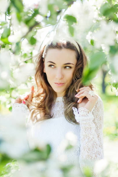 istock Beautiful brunette posing in blossoming apple-trees 813452396