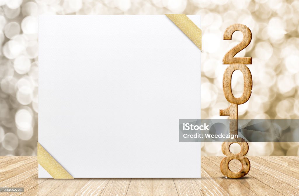 Happy new year 2018 with blank white greeting card with gold ribbon in perspective room at sparkling bokeh wall and wooden plank floor,leave space for display of design Happy new year 2018 with blank white greeting card with gold ribbon in perspective room at sparkling bokeh wall and wooden plank floor,leave space for display of design. 2018 Stock Photo