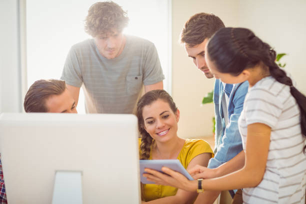 istock Creative business team gathered around a tablet 813455880
