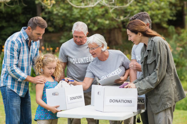 istock Happy volunteer family separating donations stuffs 813463480