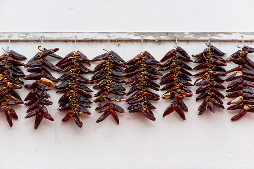 Strings of PDO Espelette chilli peppers drying, France