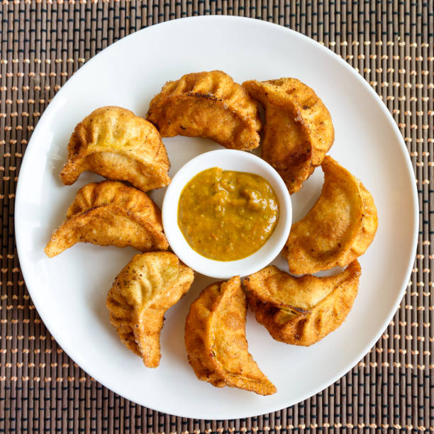 Fried Nepalese momos Plate of fried Nepalese momos and its achar (sauce) chinese dumpling photos stock pictures, royalty-free photos & images