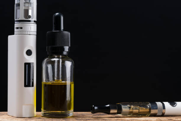 istock Two different electronic cigarettes to choose from for refilling on a wooden table 813464586