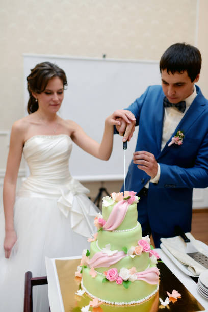 istock Beauty bride and handsome groom are cutting a wedding cake 813468874