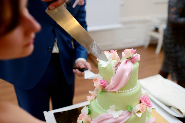 istock Beauty bride and handsome groom are cutting a wedding cake 813468980