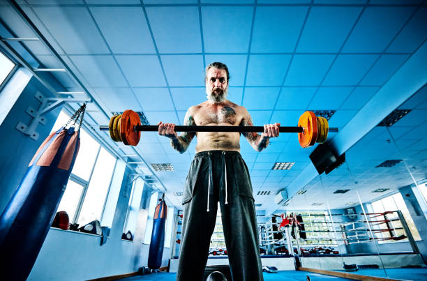 A Strong Athletic Man Sits in the Gym on the Simulator Stock Photo - Image  of black, heavy: 229621586