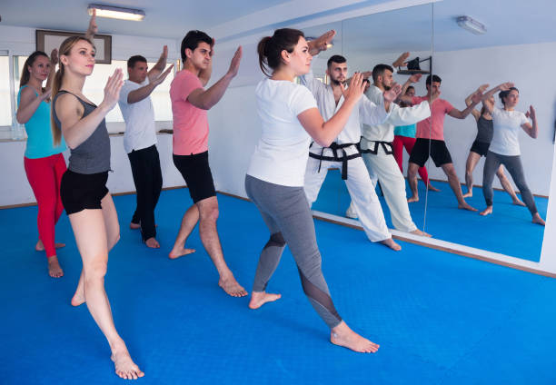 istock adults attempting to master new moves during karate class 813485438