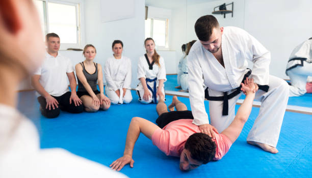 istock Coach explaining painful hold in taekwondo class 813485480