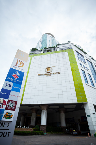 Capture of facade of The Berkeley Hotel Pratunam in Bangkok seated at Phetchaburi Road. At left side are many banners on sidewalk.