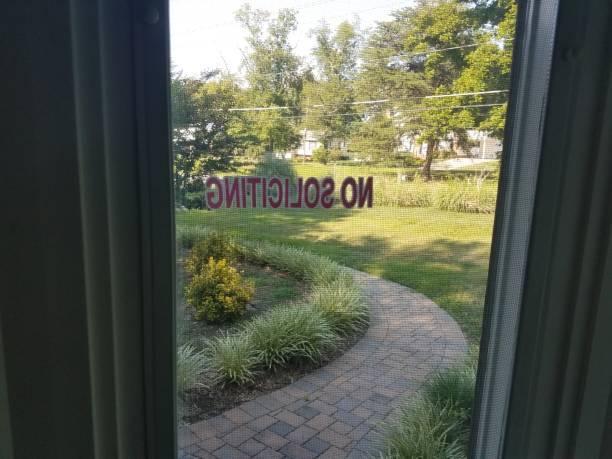 istock no soliciting sign on window from inside house looking out 813504902