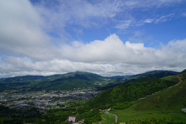 istock Lush greenery mountain landscape panorama and town view with cloudy blue sky 813525836