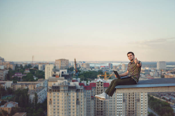 istock Hipster with laptop on roof 813553918
