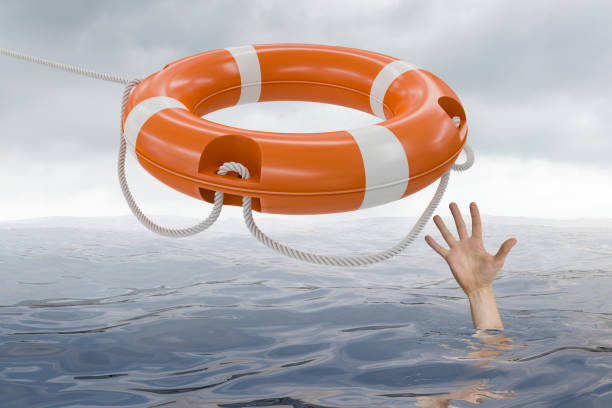 istock Man is drowning in ocean and is catching life buoy. 813565522
