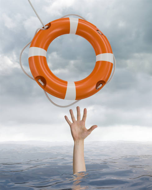 istock Man is drowning in ocean and is catching life buoy. 813565542