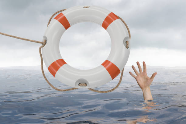 istock Man is drowning in ocean and is catching life buoy. 813565552