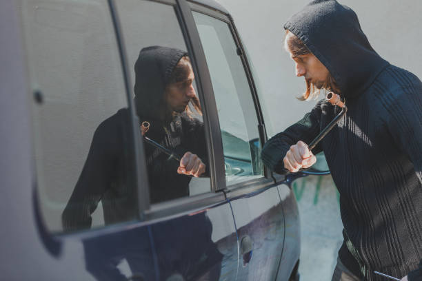 istock Thief burglar breaking smashing the car window 813568230