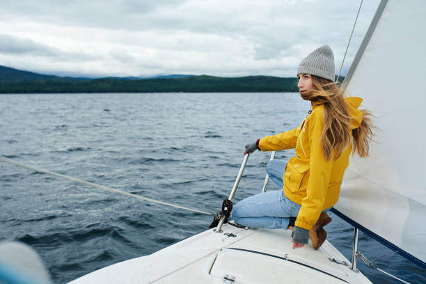 Young strong woman sailing the boat stock photo