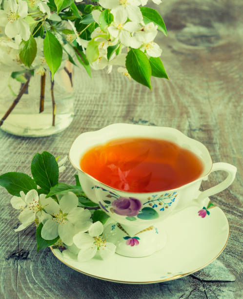 istock Cup of tea with apple tree flowers toned 813575076