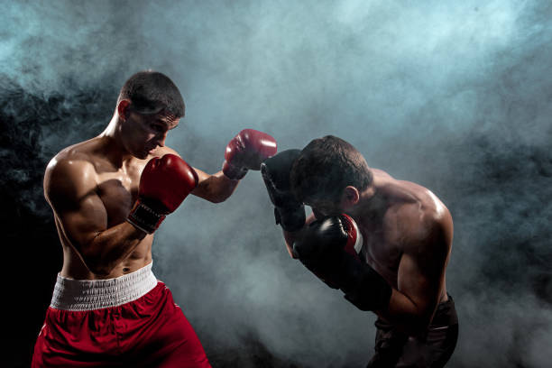 istock Two professional boxer boxing on black smoky background 813575520