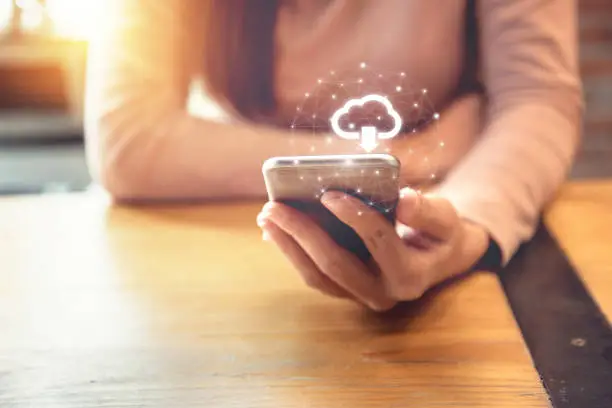 Closeup hand of woman with Cloud download on mobile smartphone, copy space